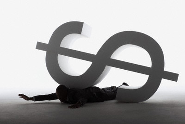 Businessman trapped under a dollar sign --- Image by © Beau Lark/Corbis